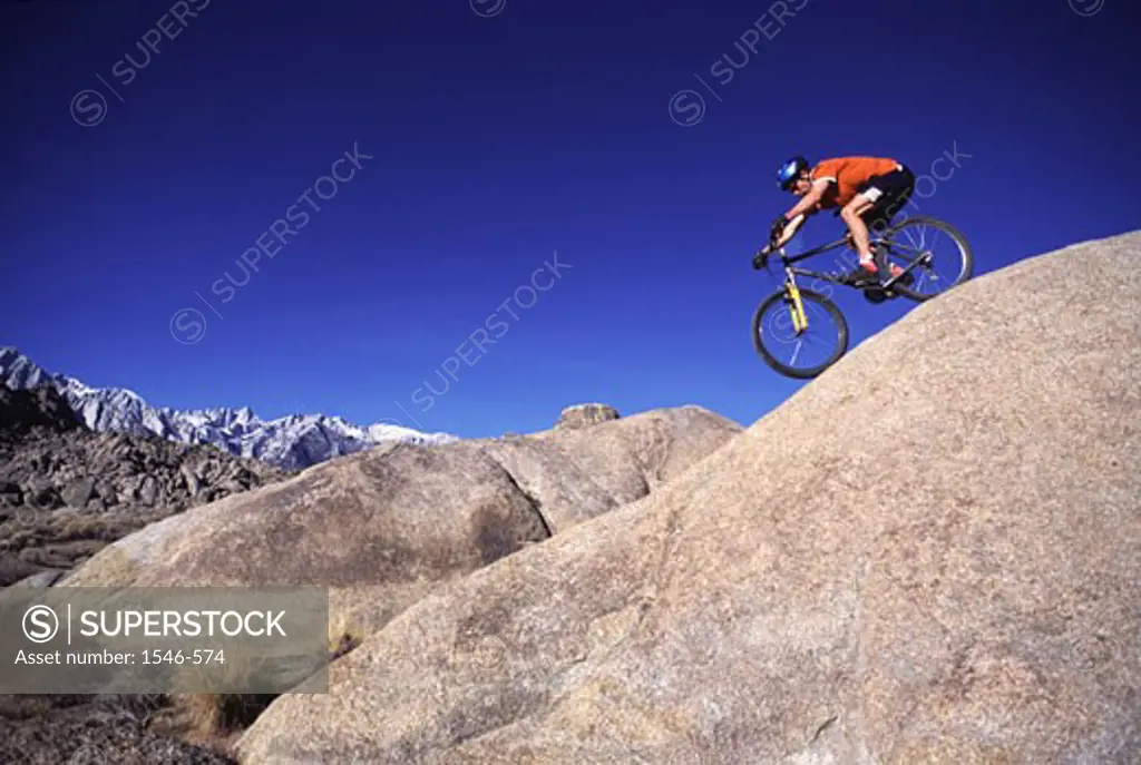 Low angle view of a man riding a mountain bike on a hill
