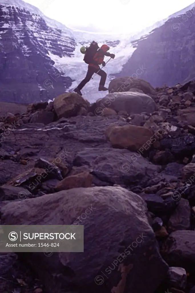 Side profile of a mountaineer jumping from rock to rock, Alberta, Canada