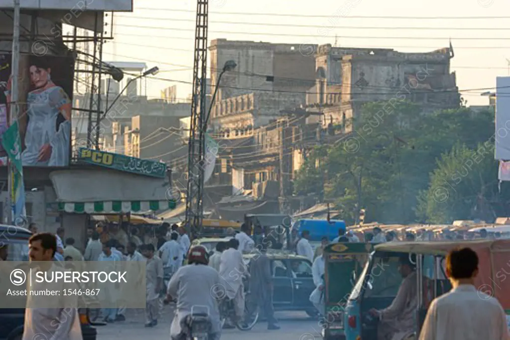 Street scene with pedestrians old buildings pollution and vehicles, Rawalpindi, Pakistan
