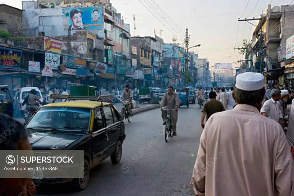 Street scene with pedestrians old buildings pollution and vehicles, Rawalpindi, Pakistan