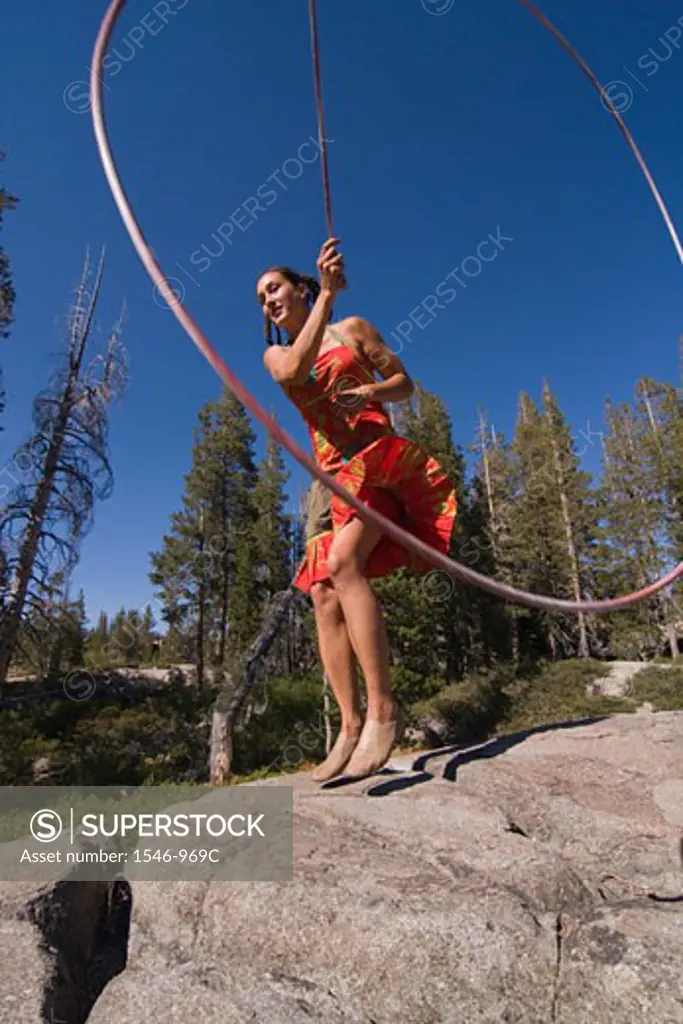 Woman practicing with a lariat in a forest