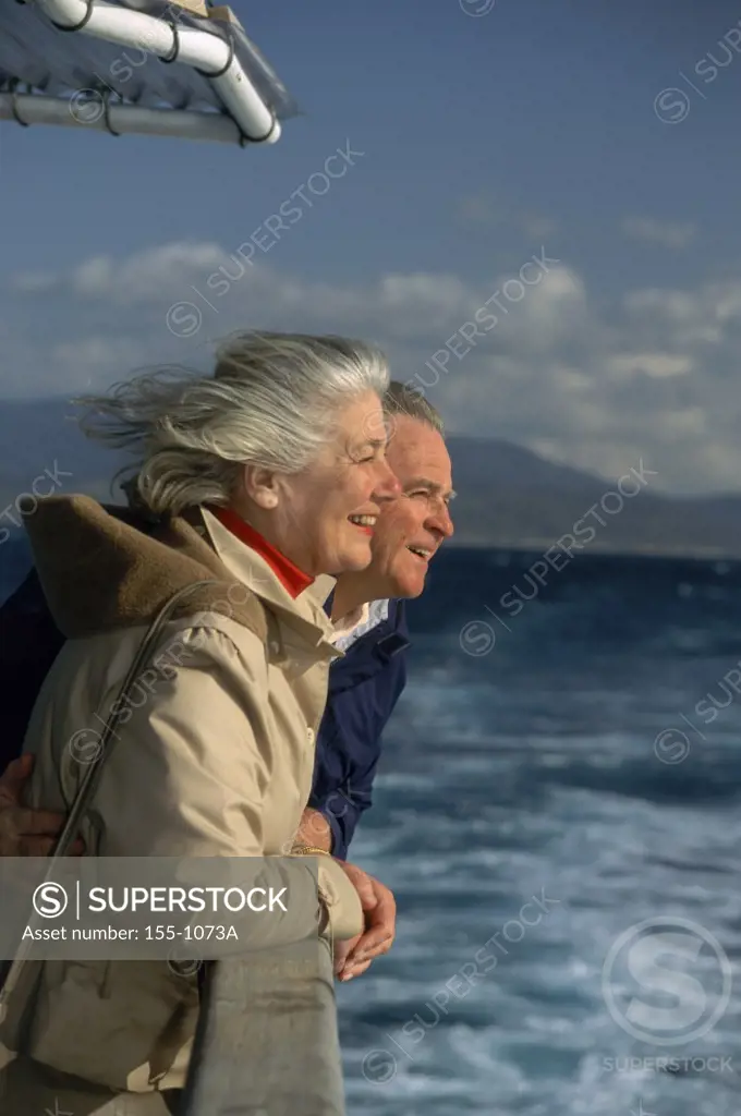 Senior couple looking at sea view from deck of a ship