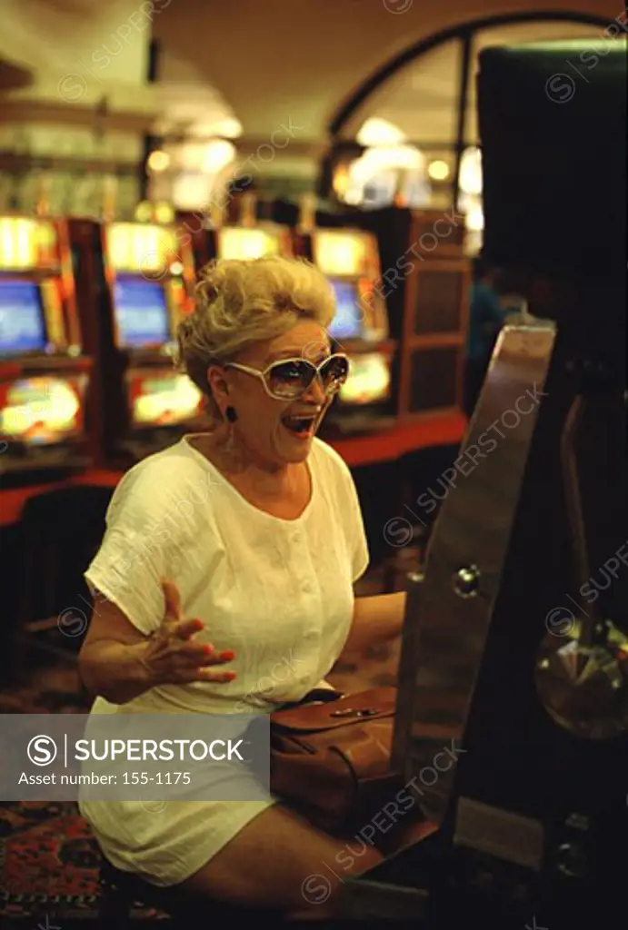 Mature woman gambling on a slot machine in a casino, Laughlin, Nevada, USA