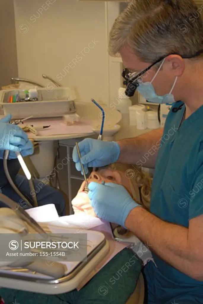 Dentist with his assistant examining a patient