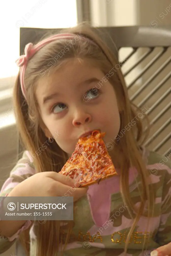 Close-up of a girl eating pizza