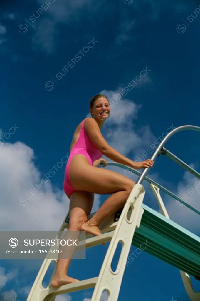 Young woman moving up on steps of a diving board