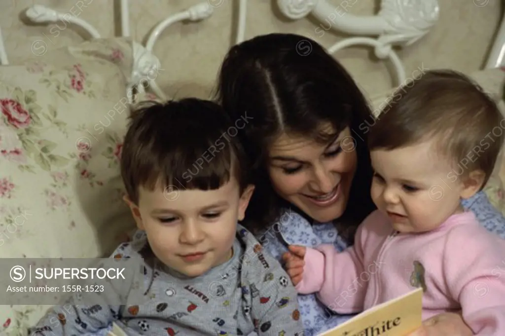 Mother reading a book to her two children