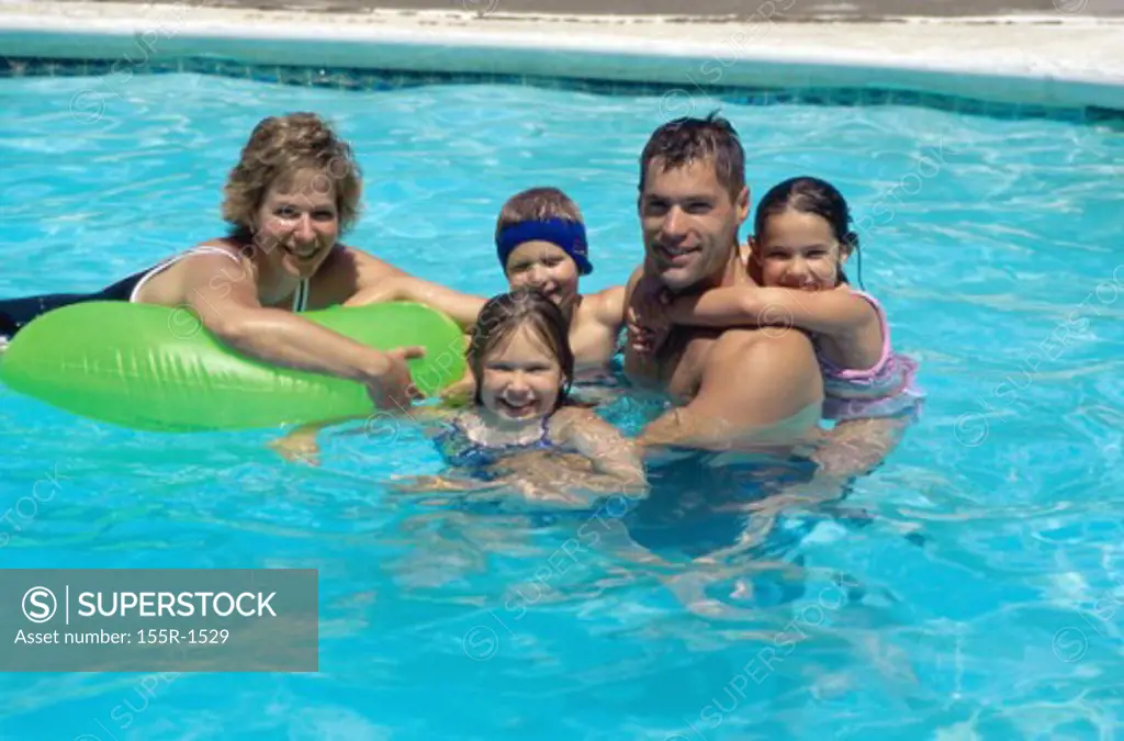 Father and mother with their son and two daughters in a swimming pool