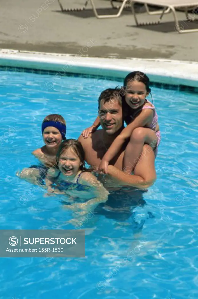Portrait of a father with his children in a swimming pool