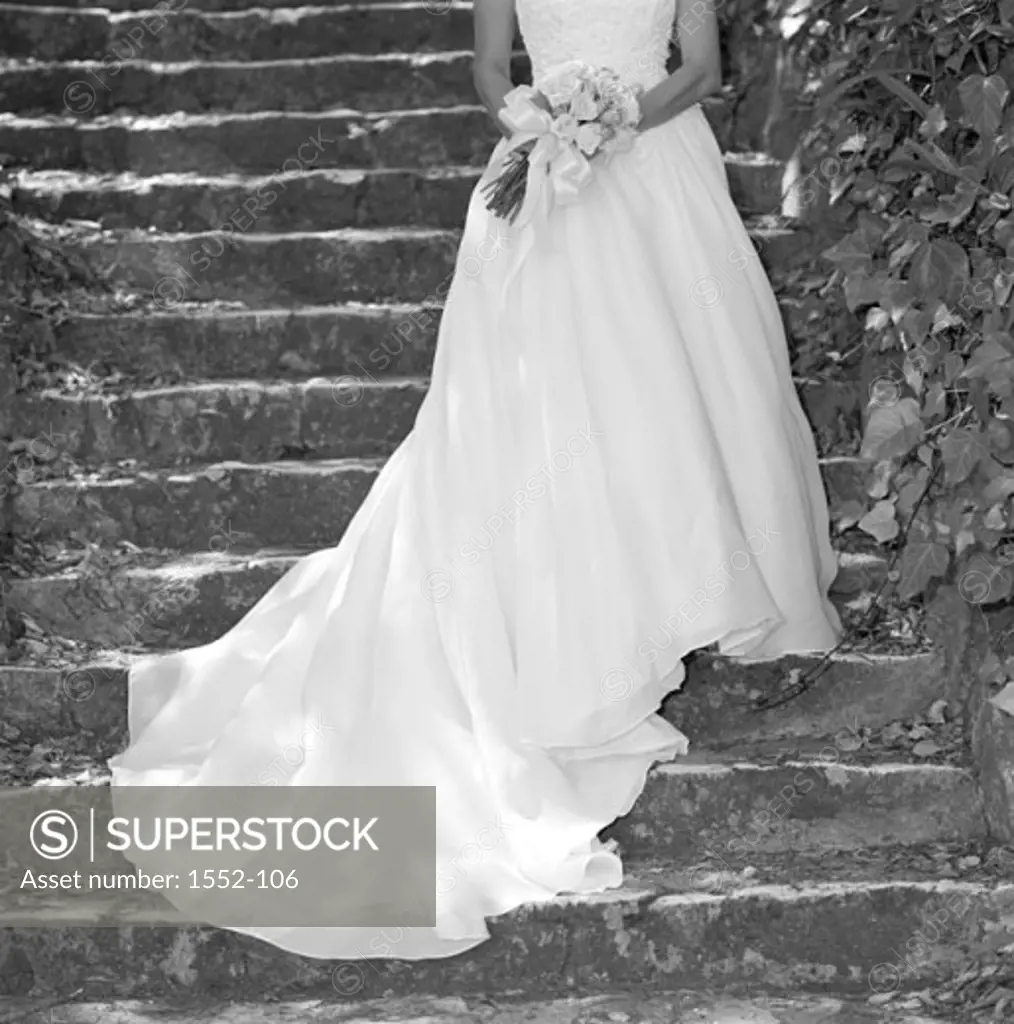 Bride standing on steps holding a bouquet