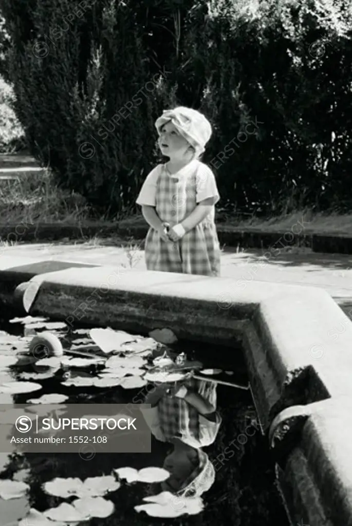 Girl standing near a pond