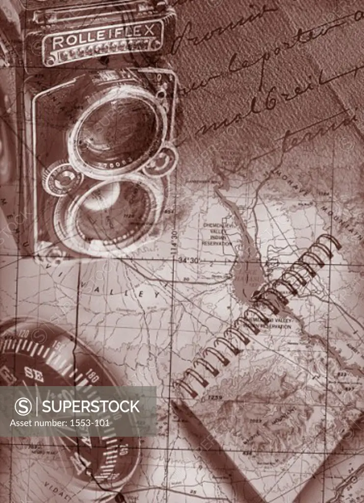 High angle view of a camera and a notebook superimposed on a map