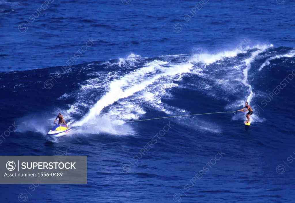 Surfer being pulled by jet skier