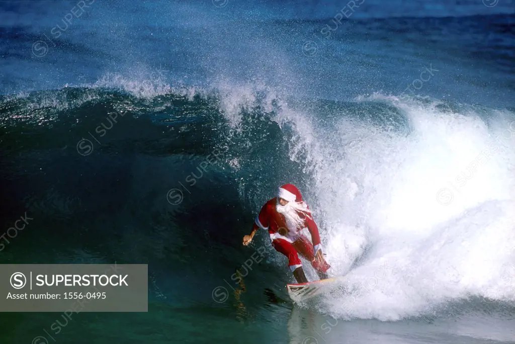 Santa Claus surfing a wave