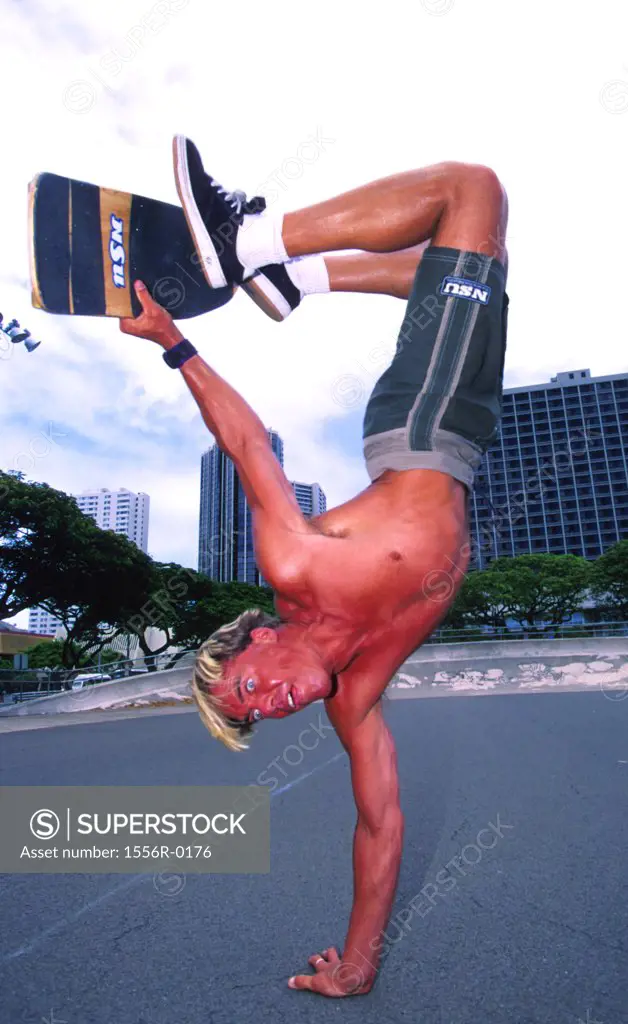 Young adult man performing stunt on skateboard, Newport, Rhode Island, USA
