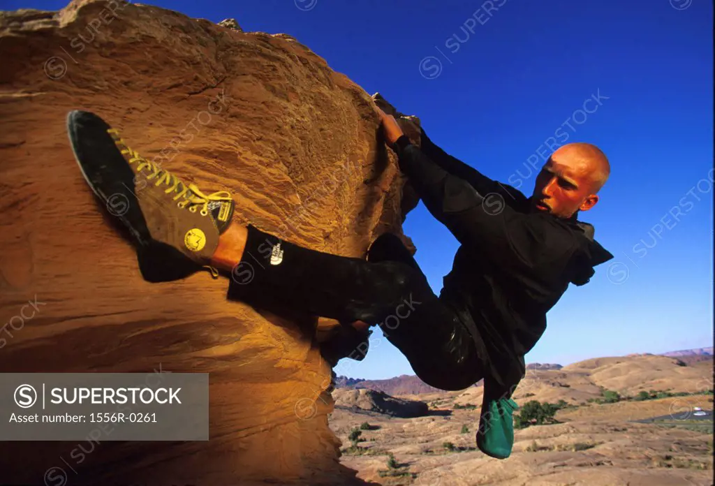 Young adult man mountain climbing, Utah, USA