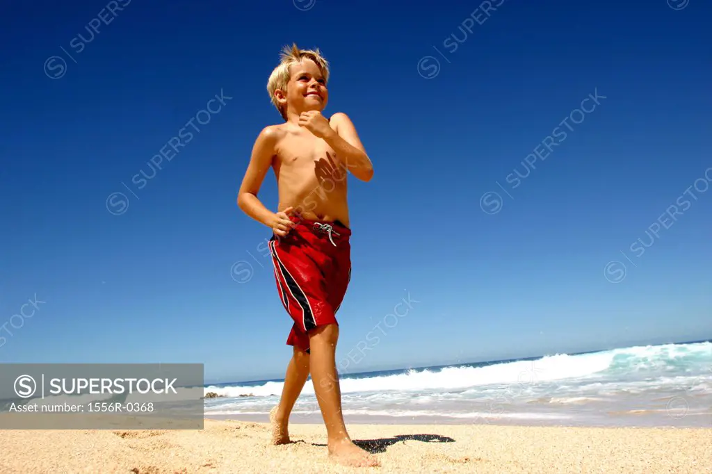 Boy strutting down beach