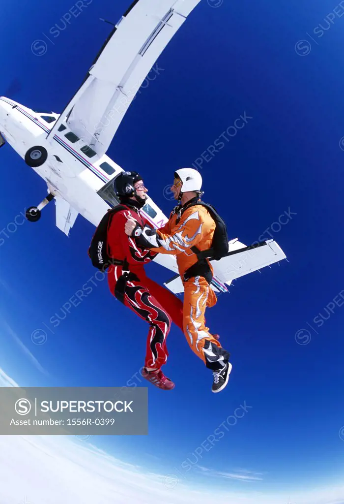 Two young adult men skydiving (fish-eye lens)
