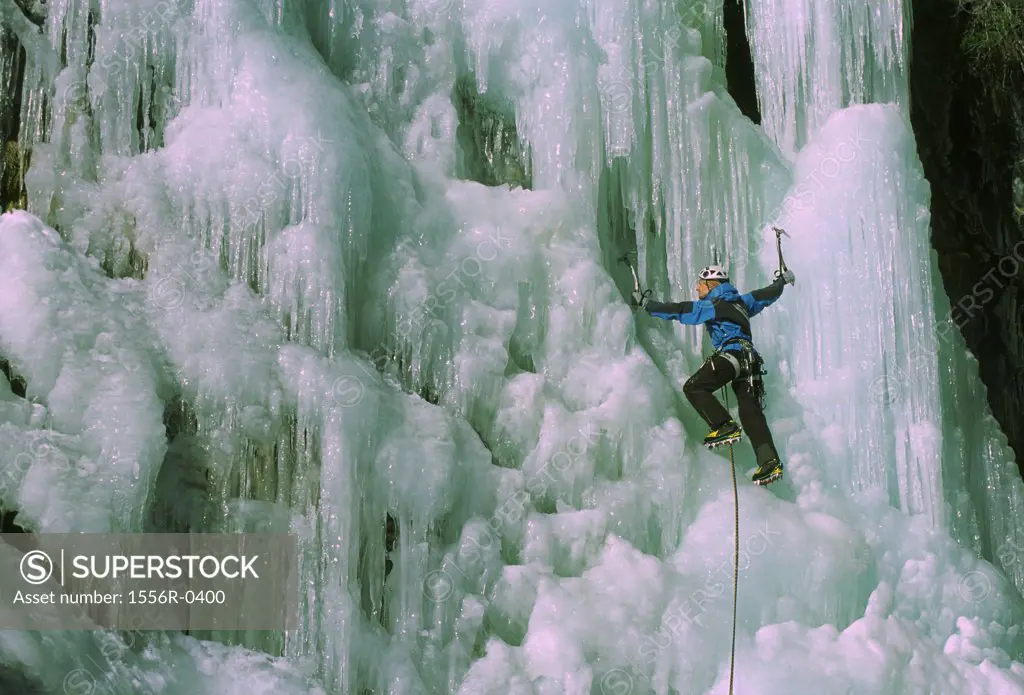 Young adult man ice climbing, Italy