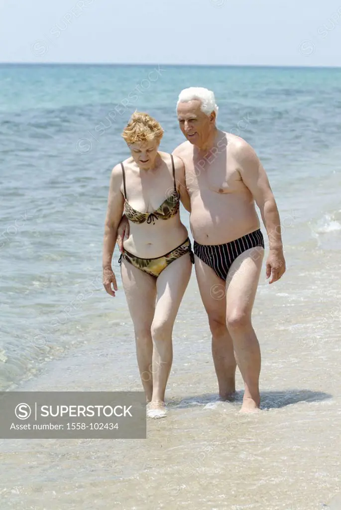 Senior couple, Badekleidung,  Beach walk,   Seniors, couple, enjoying relationship, togetherness, trunks, bikini 60-70 years, partnership, retirement ...