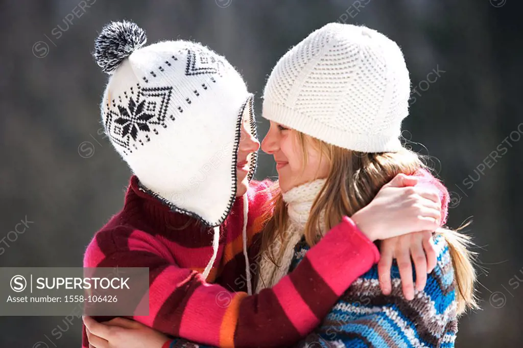 Girls, caps, winter-clothing, cheerfully, embrace, gaze-contact, side-portrait, winters, leisure time, vacation, winter-vacation, vacation, winter-vac...