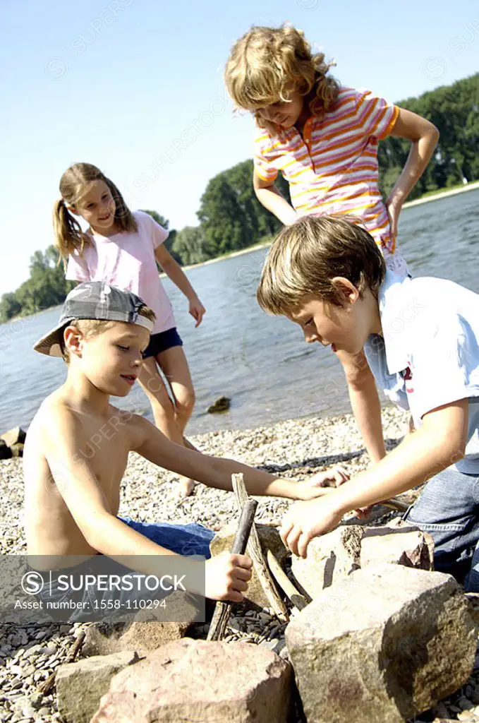 Riversides, children, fire-place, plays, series, people, 8-10 years, friends, boys, girls, grill-place, stones, wood, firewood, grill-fires, ignites v...