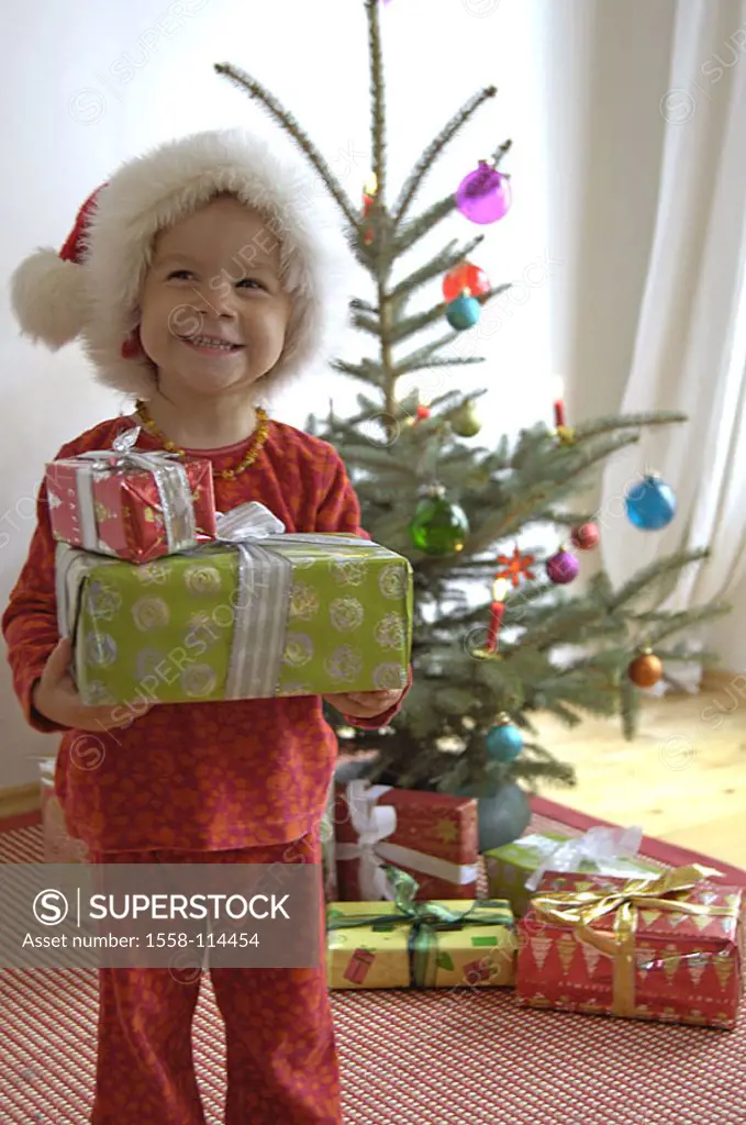 Christmas, sacred evening, child, Nikolaus-cap, cheerfully, gifts, holds, grins, with pride, Christian-tree, living rooms, Christmas time, Christmas E...