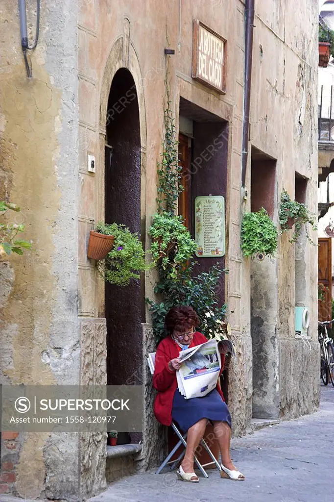 Italy, Tuscany, Pienza, alley, entrance, woman, chair, sits, newspaper reads, , city, idyllically, residence, stone-house, business, facade, windows, ...