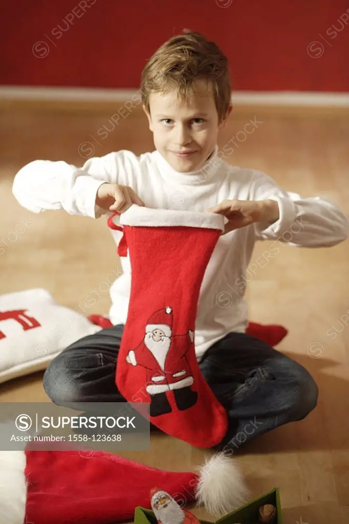Give birth, sits cheerfully, floor, Nikolaus-stocking, squeals, series, people, child, 6-8 years, childhood, cap, Nikolaus-cap, Advent, living rooms, ...