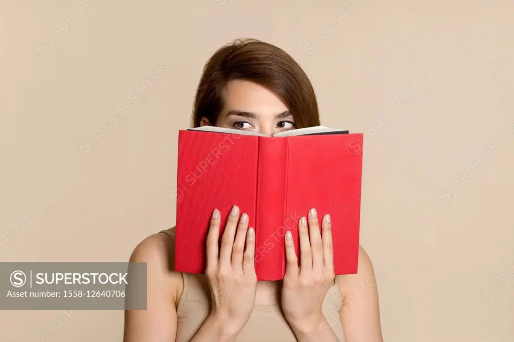 Woman hides behind a book, portrait,