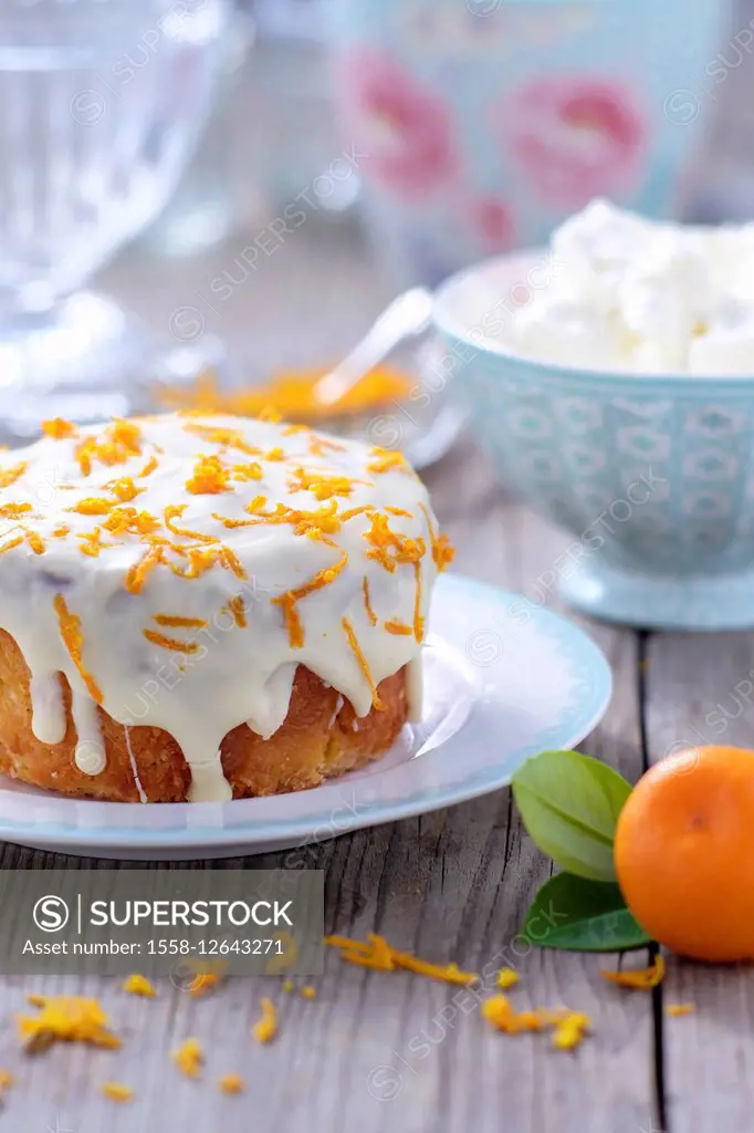 Small orange cake with white icing on plate