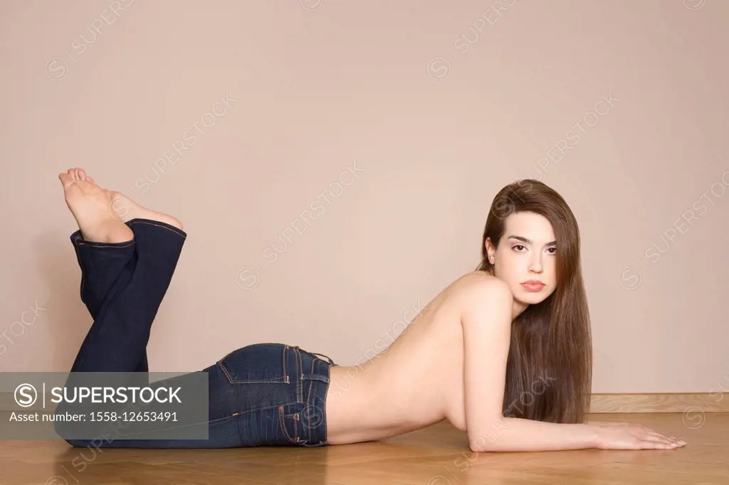 Woman, young, jeans, topless, floor, lie, facing camera,