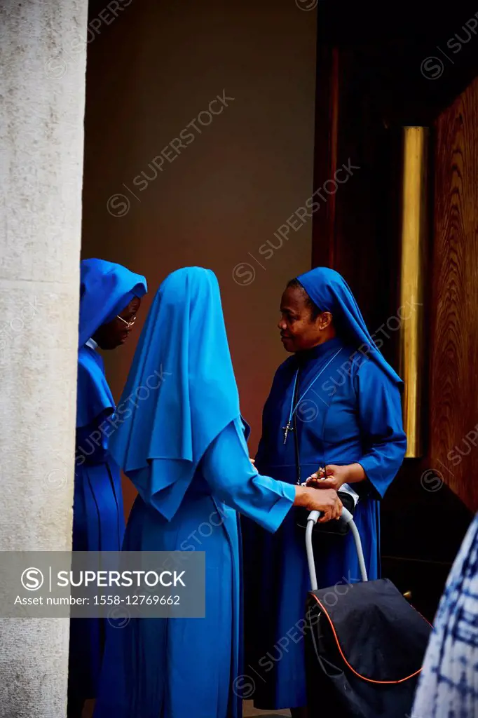 3 nuns, blue garments, talking, house entrance, Rome, Italy