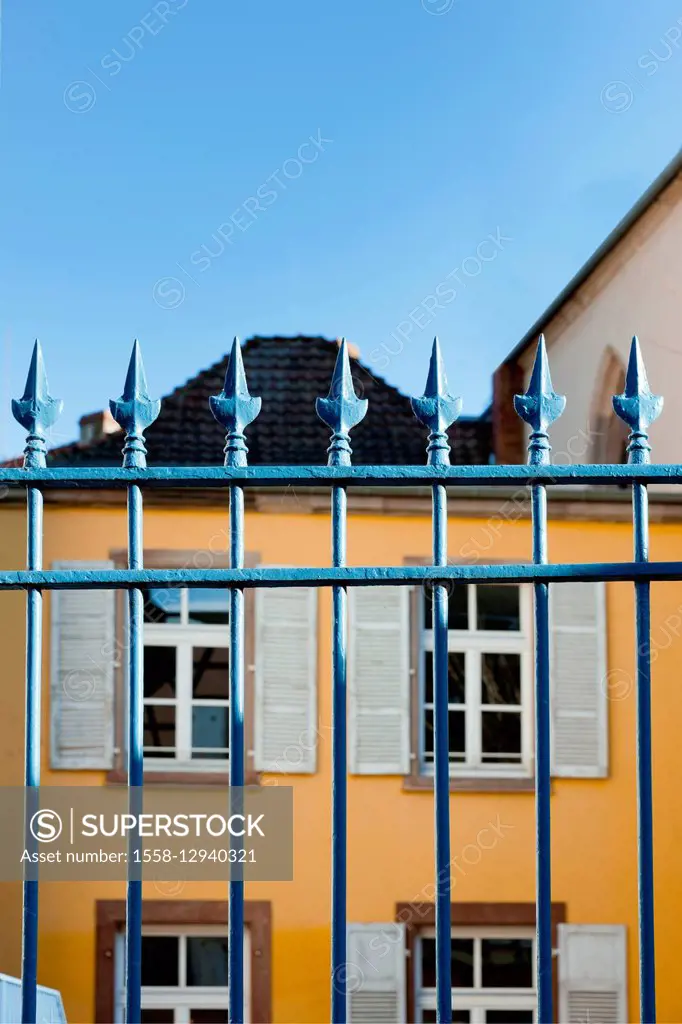Iron fence in front of yellow building