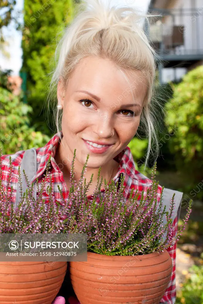 Young woman with heather in the garden