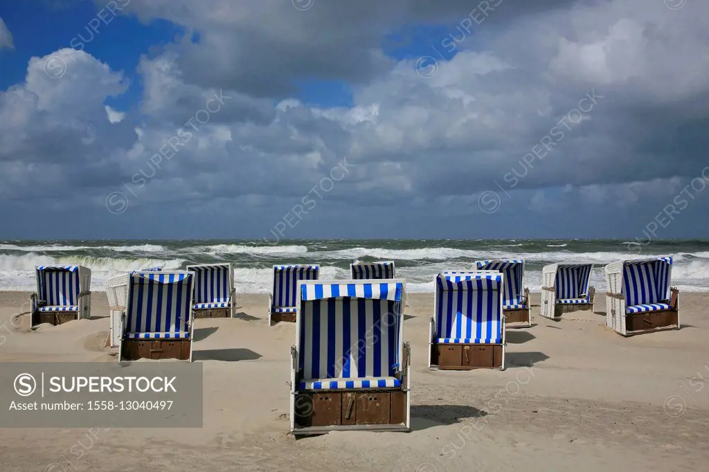 Beach chairs on the beach of Kampen (municipality) on the island of Sylt, behind it storm-beaten North Sea