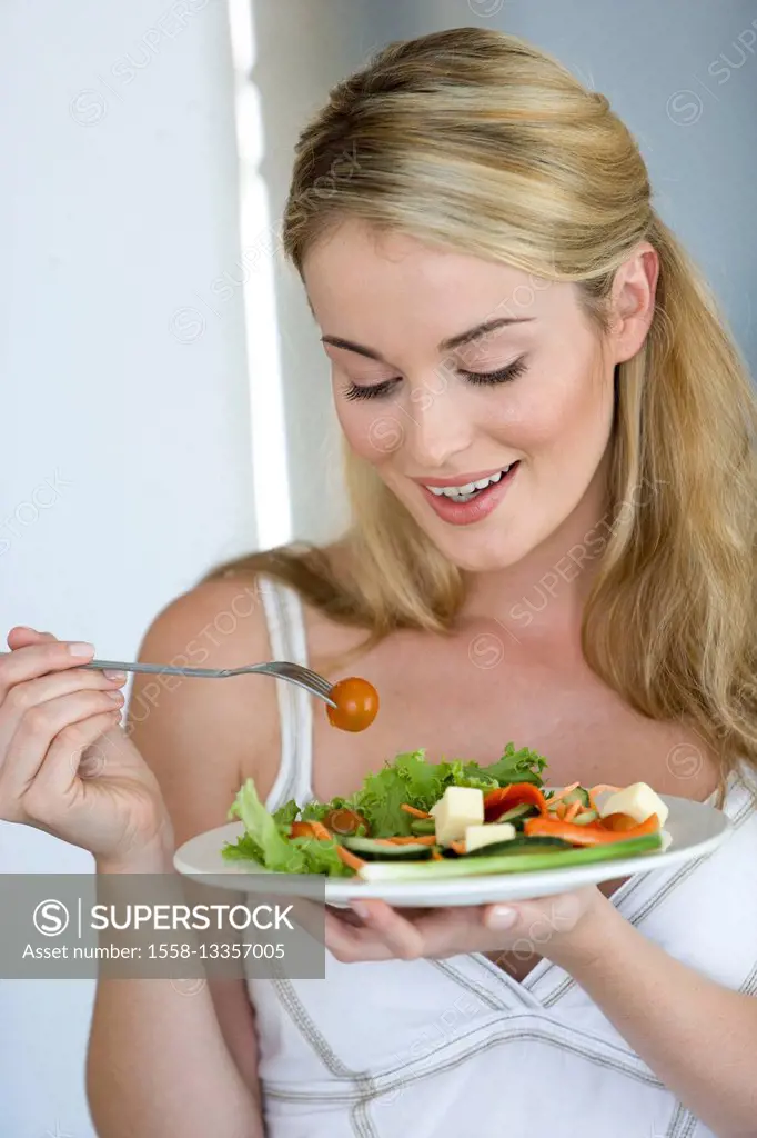 Young blond woman with salad plate