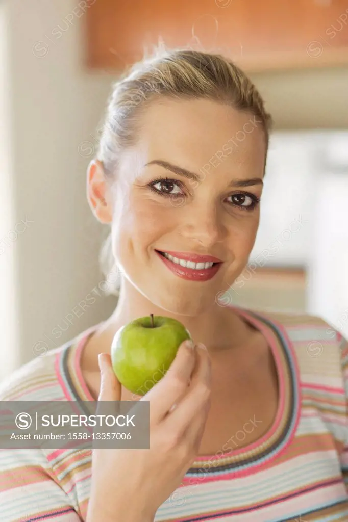 Young blond woman with green apple
