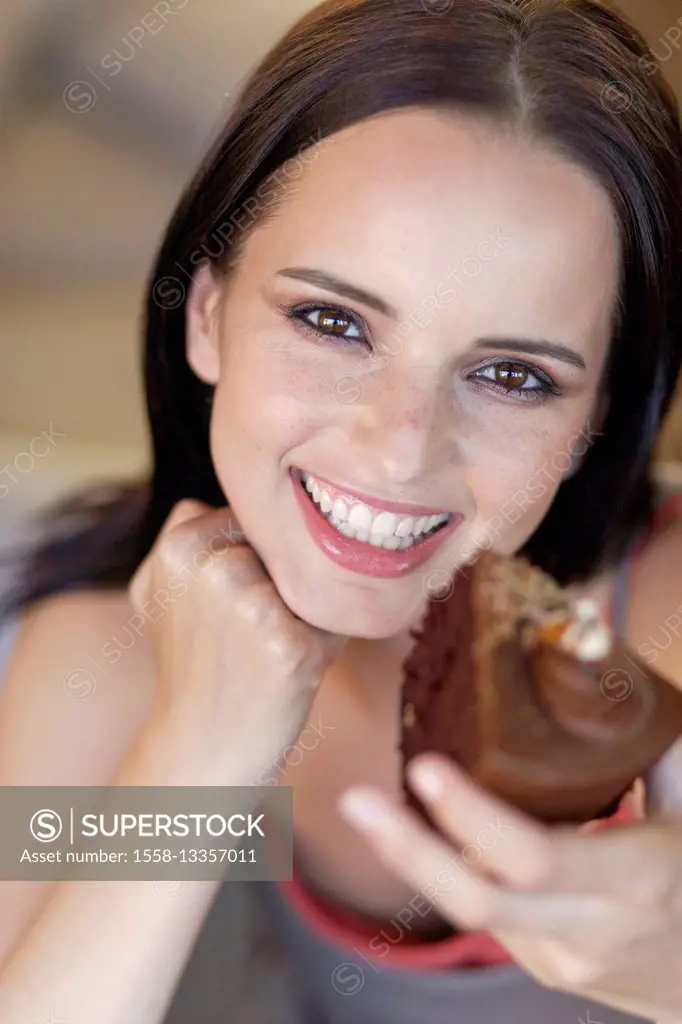 Young dark-haired woman is enjoying chocolate cake