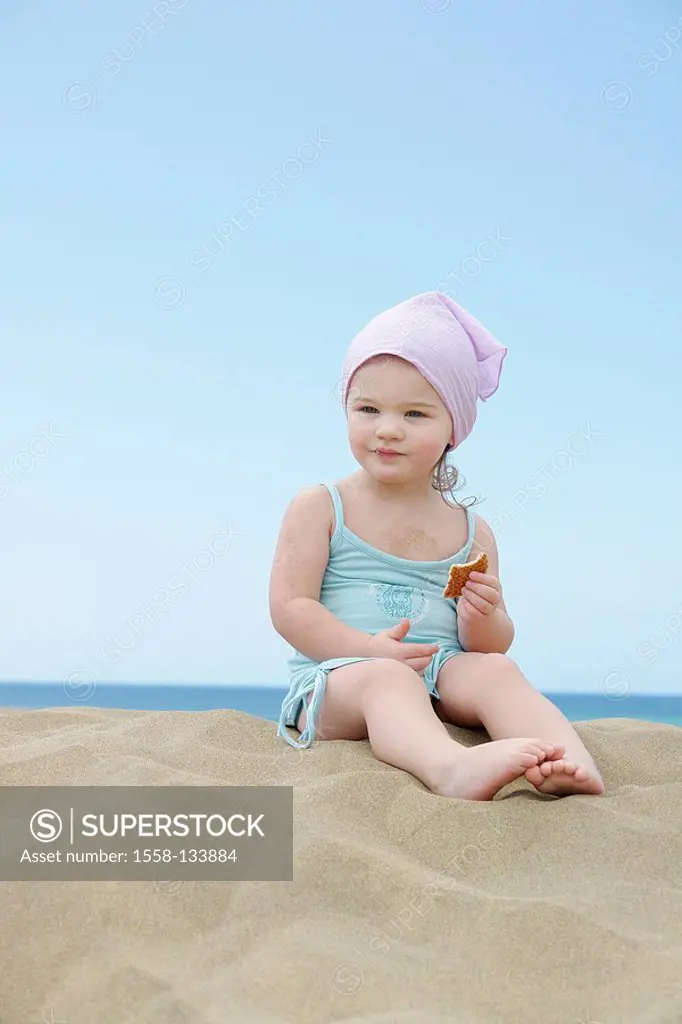 Sits toddler, beach, cookie, eating,