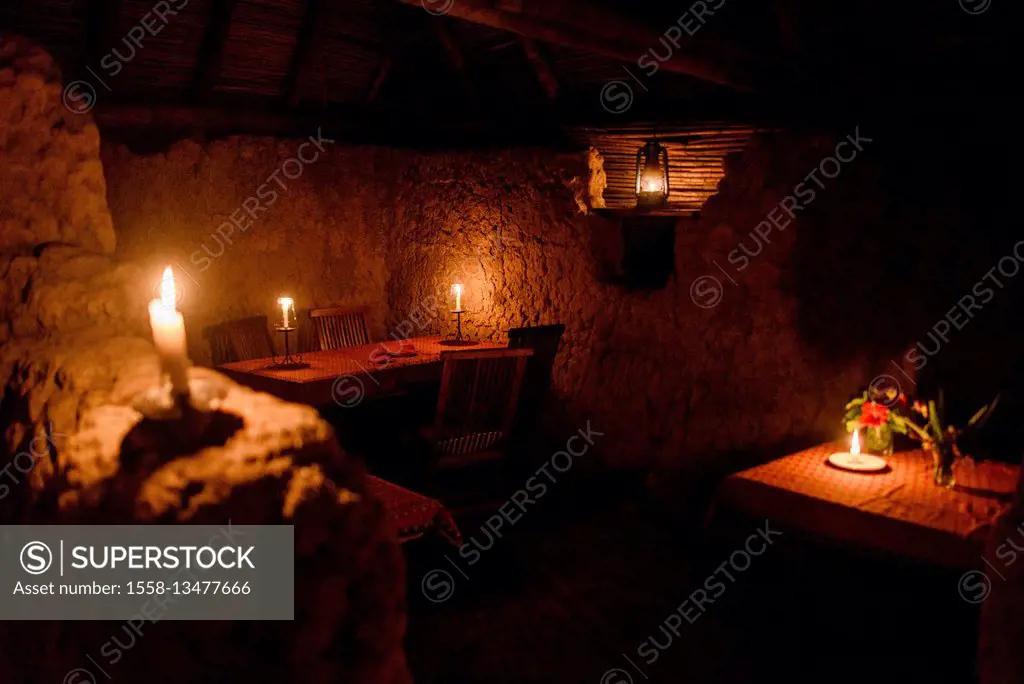 In a restaurant in Tanzania with candlelights and without electricity