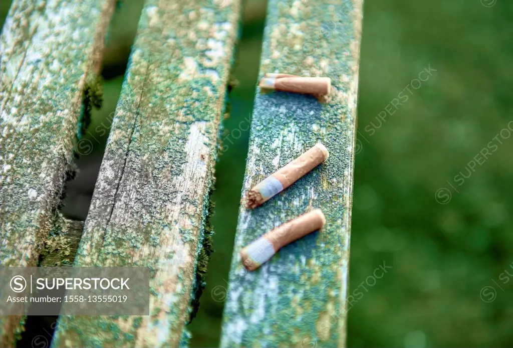 Cigarette end, weather-beaten wooden table, garden