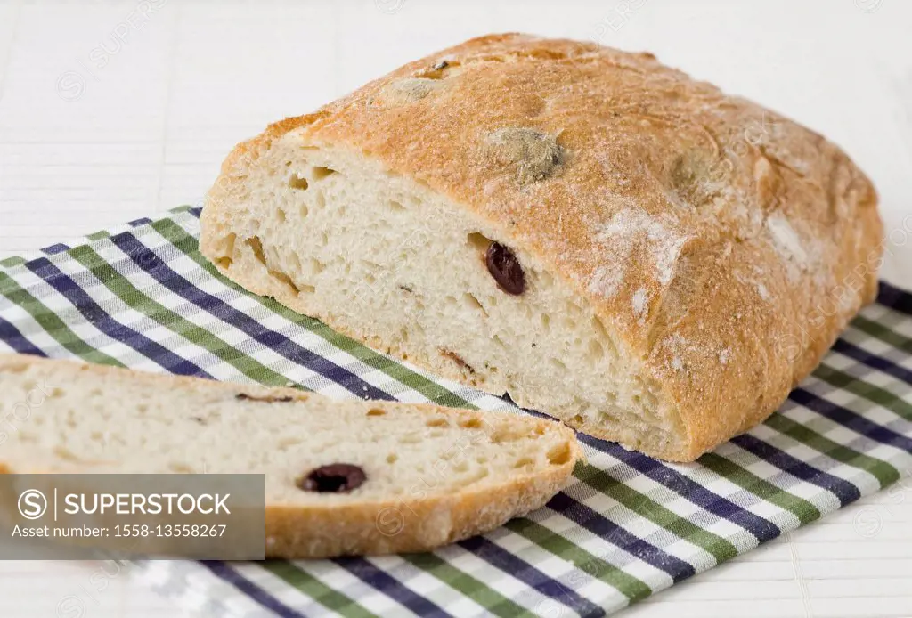 Olive bread cut on checked napkin
