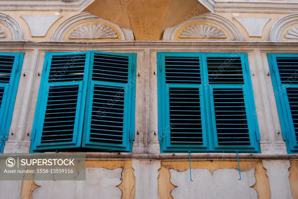 Morbid house facade with yellow-white rendering and frescoes and turquoise shutters in Pisa, capital of the province of Pisa, Italy, Tuscany,