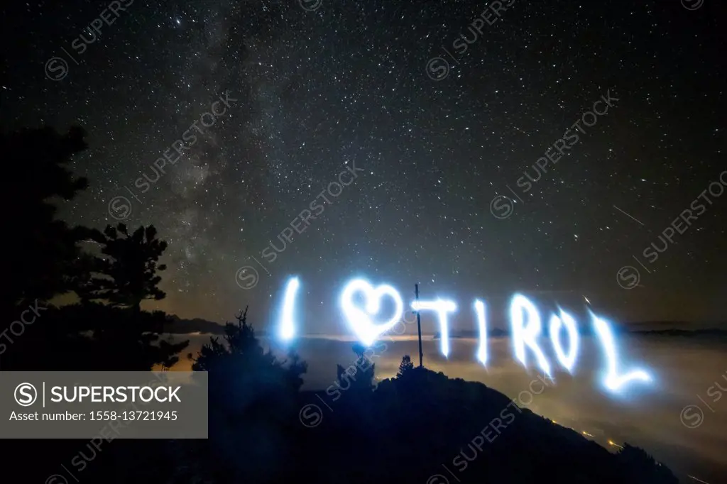 Light Painting 'I love Tirol' with the Milky Way and the summit cross in the background