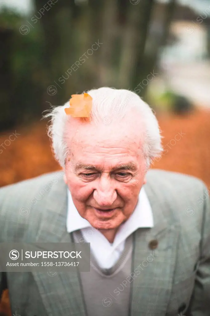 Senior at autumn walk, leaf on his head