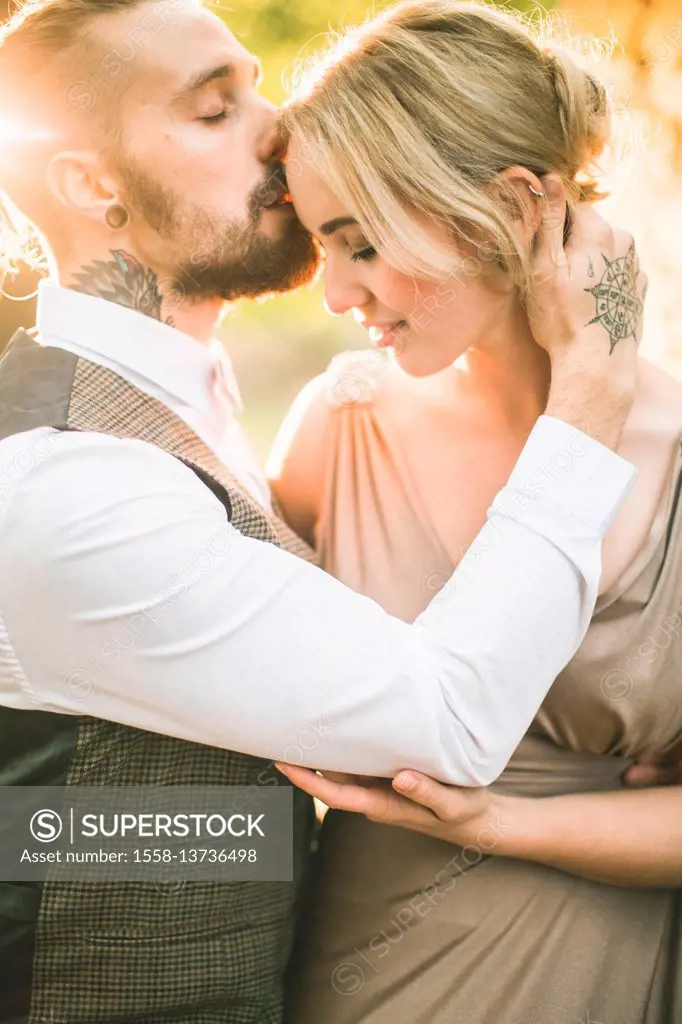 Young couple, natural, happy, in love, embrace, kiss on the forehead