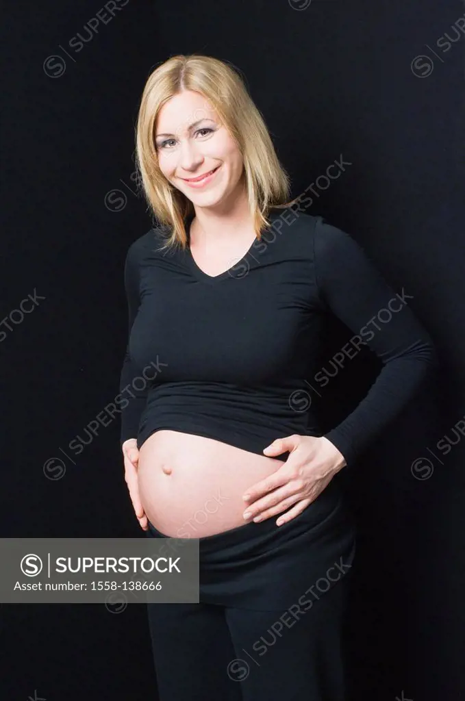 Woman, young, pregnant, happily, presents navel-freely, belly, with pride, smiling, touch, people, blond, pregnant, stands, with pride, pregnancy, mot...