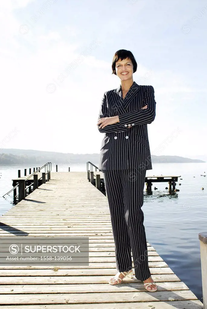 Woman, smiling, stands, bridge, lake, series, people, 30-40 years, brunette, pant suit, businesswoman, leisure time, summer, sunny, outside, full-leng...