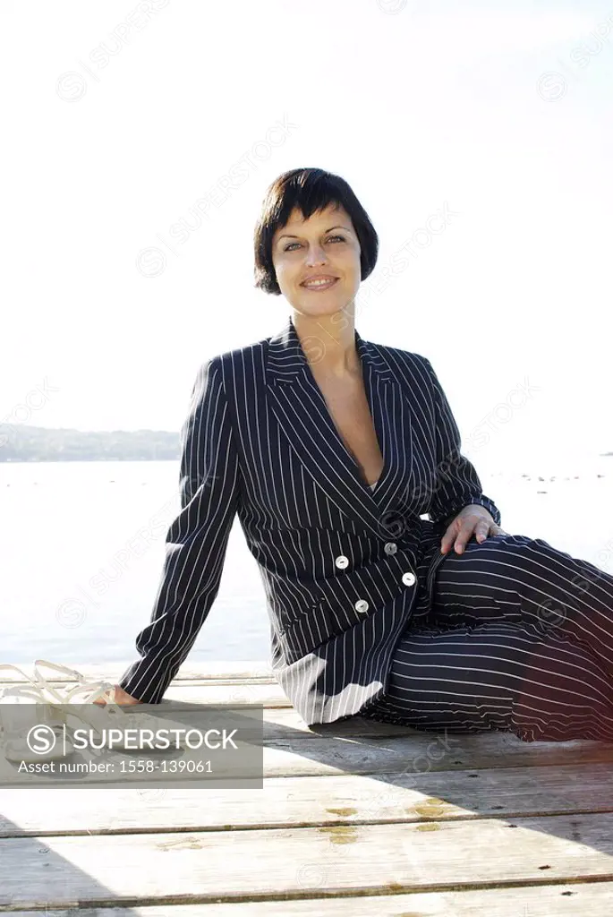 Woman, smiling, sits, bridge, lake, series, people, 30-40 years, brunette, pant suit, businesswoman, leisure time, summer, sunny, outside, enjoys watc...